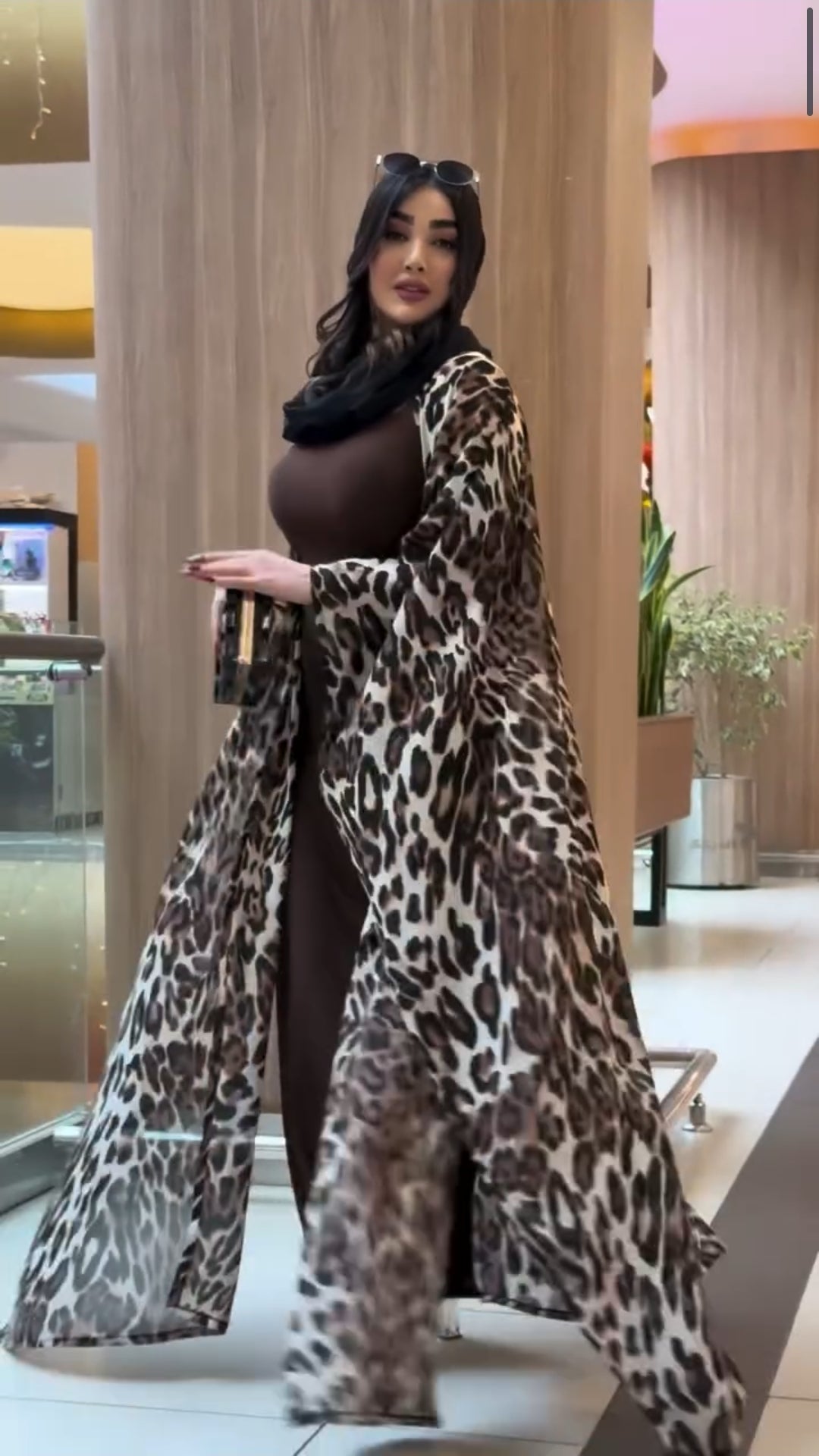 Woman wearing a leopard print coat in an indoor setting