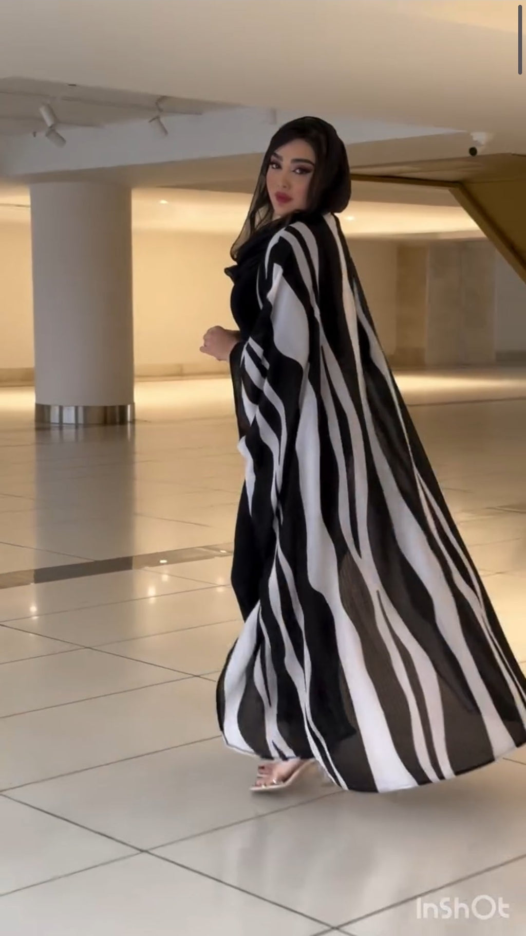 Woman wearing a black and white striped dress in an indoor setting