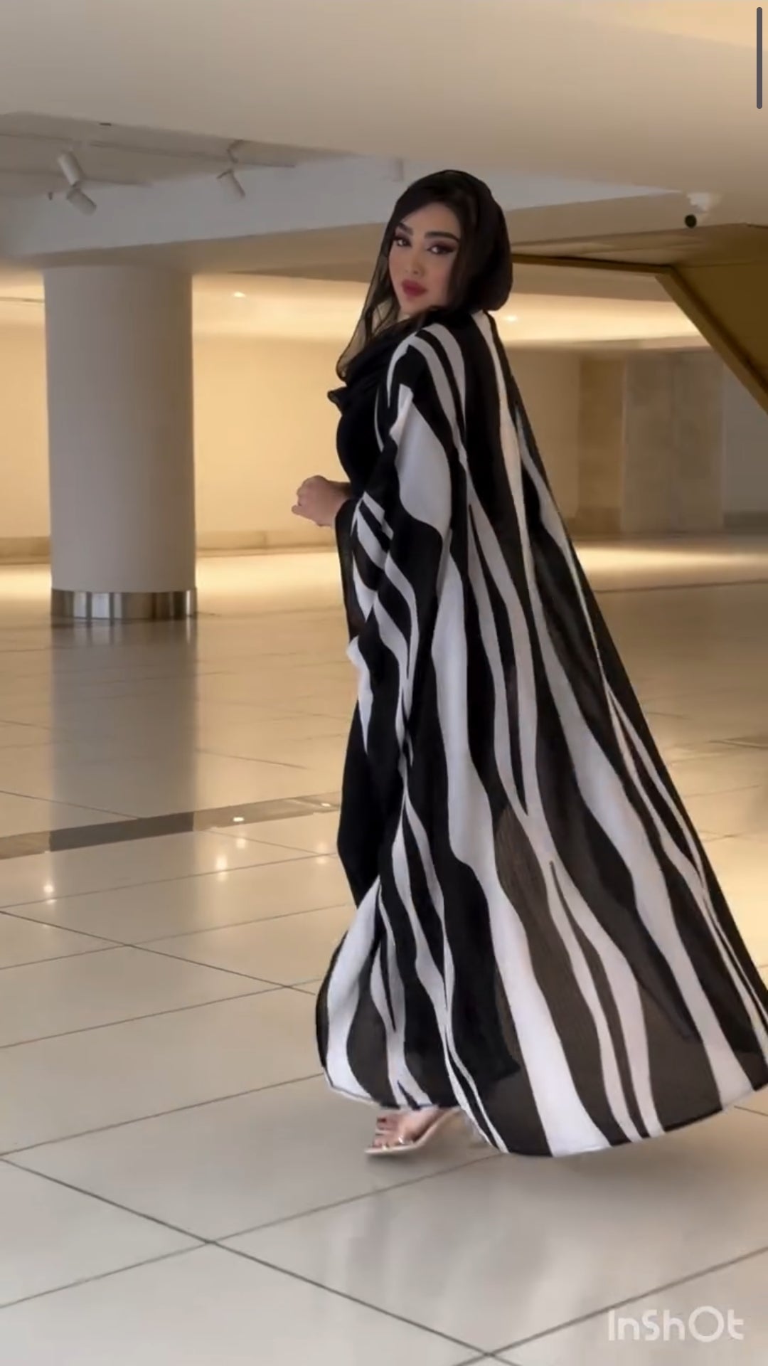 Woman wearing a black and white striped dress in an indoor setting